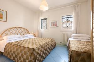 利多迪耶索罗Villa Carlotta Jesolo Lido的一间卧室设有两张床和两个窗户。