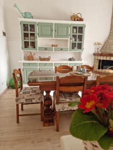 阿西西La Casa dei Fiori的厨房配有绿色橱柜和桌椅
