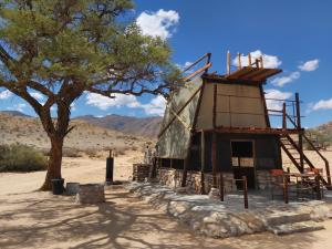 索利泰尔Camp Gecko - PRIVATE NATURE RESERVE; TENTED CAMP AND CAMPSITE的沙漠中一座有树的建筑