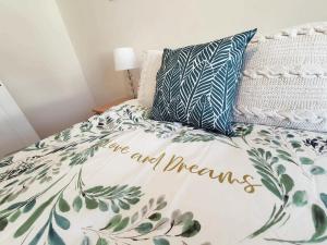 安布尔Brodie's Hideaway: Stylish two-bed Amble apartment的一张带床罩的睡床,床罩是阅读的,是梦