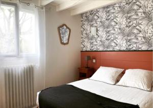 Saint-Jean-le-Vieux波提嘉乡村别墅的一间卧室配有床和壁画