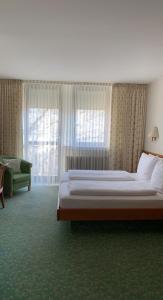 曼海姆科法尔斯图本酒店的一间卧室配有一张床、一张沙发和窗户。