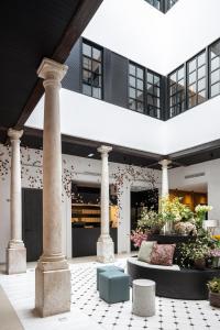 马拉加TOC Hostel Malaga的庭院中一座有柱子和鲜花的建筑