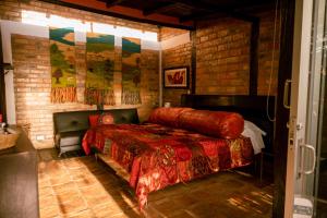 莱瓦镇塞雷纳宾馆的一间卧室设有一张床和砖墙