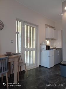加藤-达拉特索Sunshine Apartments的厨房配有桌子和白色冰箱。