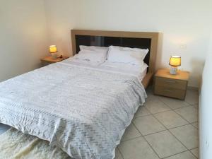 萨尔雷Sal Rei apartaments, Boa Vista, free WI-FI的一间卧室配有一张带2个床头柜的大型白色床