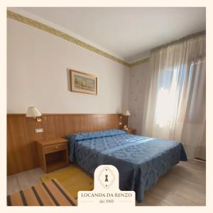 特雷维索罗坎达大伦佐酒店的一间卧室设有蓝色的床和窗户。