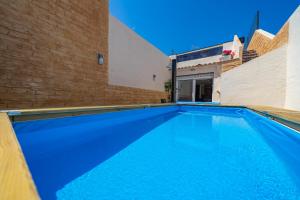 皮内达德马尔HomeHolidaysRentals Benoit - Costa Barcelona的砖墙旁边的大型蓝色游泳池