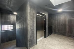 切拉德纳Apartmán v Tee house Čeladná的走廊上设有门,位于一间拥有黑色墙壁的房间