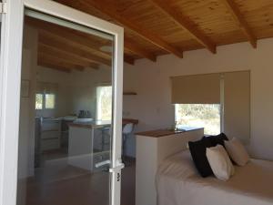 玛德琳港Coralillos的一间卧室配有一张床,厨房配有窗户