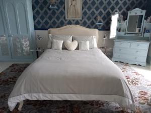 Stranocum花园谷庄园宅邸住宿加早餐酒店的卧室配有白色大床和蓝色的墙壁
