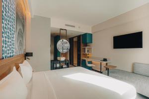 丹吉尔Occidental Tanger的一间酒店客房,配有一张床和一台电视