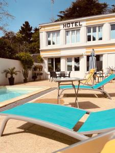 圣让-德蒙Hôtel Casita del Mar的游泳池畔的酒店设有桌椅
