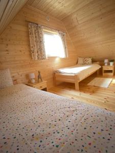 BodzentynDomek na Wsi的小木屋内一间卧室,配有两张床