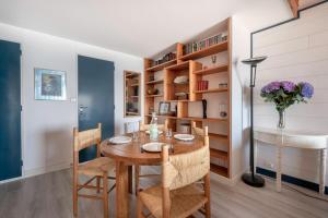 阿尔宗VUE MER Vacances en famille a cinq a Arzon的一间带木桌和椅子的用餐室