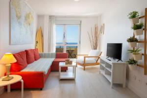 大加那利岛拉斯帕尔马斯La casita de Matilda, 1A的客厅配有红色沙发和电视