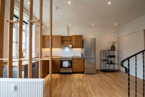 森讷堡Stylish two floor Deluxe Apartment - 2 bedroom的厨房配有木制橱柜和不锈钢冰箱。