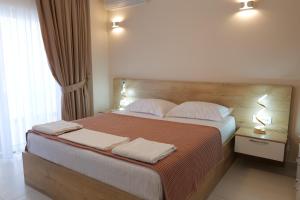 萨兰达Saranda Luxury Apartments的一间卧室配有一张大床和两条毛巾