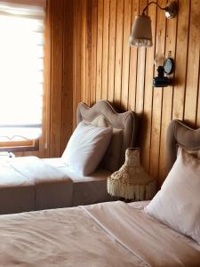 乌宗Selman Apart Hotel的一间卧室设有两张床,墙上配有一盏灯。