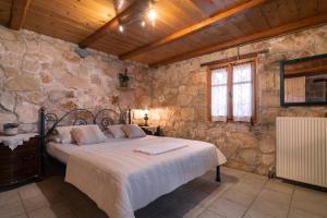 瓦西里科斯Gerakopetra的一间卧室设有一张床和石墙