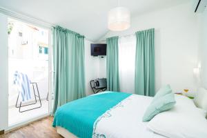 杜布罗夫尼克杰尔客房酒店的一间卧室配有绿色窗帘、一张床和窗户