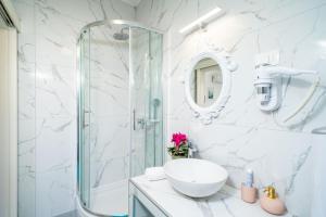 杜布罗夫尼克杰尔客房酒店的白色的浴室设有玻璃淋浴间和水槽