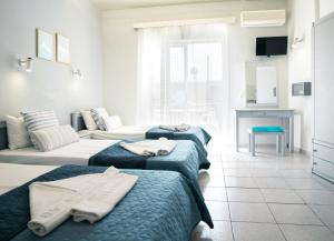 阿默达拉-伊拉克利翁RODI BLUE appartments的一间带三张床的卧室和一间客厅