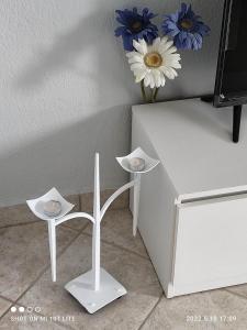 卡利塞亚-豪客迪克斯KALLITHEA Nastro Azzurro的一张带两个凳子和花瓶的白色桌子