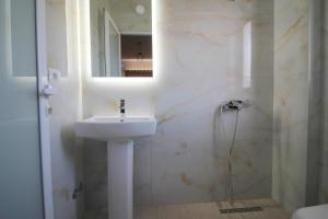 卡萨米尔J&B Hotel的白色的浴室设有水槽和镜子