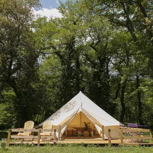 维琪奥港Domaine Authentique de Rose的田野里带椅子和树木的帐篷