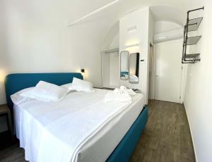 泰拉西尼L'Ulivo Comfort Rooms的一间卧室配有一张白色大床和蓝色床头板
