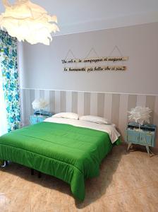 塔兰托Suite Liberty的卧室配有一张绿色的床,墙上有标志