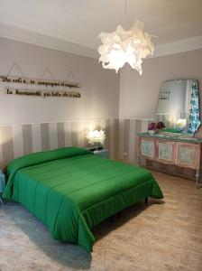 塔兰托Suite Liberty的一间卧室配有一张绿色的床和吊灯。