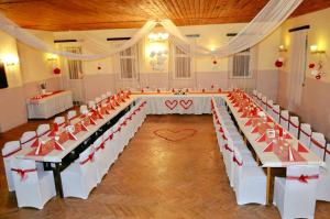 TelnicePenzion U Zeleného Stromu的宴会厅配有白色桌子和红色弓