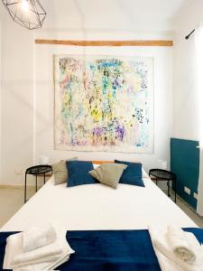 卡斯泰拉马莱DOMUS的卧室配有一张大床,墙上挂有绘画作品