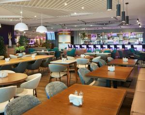 伊斯坦布尔YOTEL Istanbul Airport, City Entrance的一间带木桌椅的餐厅和一间酒吧