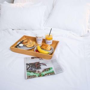 新加坡YOTELAIR Singapore Changi Airport Landside的床上的早餐盘,带杂志