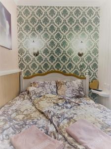 派德Renthouse Guest Apartment ALICE的一间卧室配有一张带绿色和白色壁纸的床