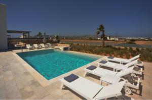 普恩达Blue diamonds villas Paros的一个带白色躺椅的游泳池和一个游泳池