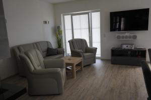 特伦特Nordlicht II的客厅配有沙发、两把椅子和电视