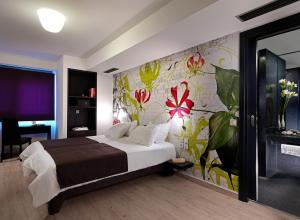 帕特雷爱若特佩特雷智能酒店的一间卧室设有一张床和花卉墙