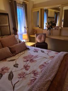 彭布罗克郡Beautiful 2 bedroom caravan, holiday park Tenby的一间卧室配有一张带花卉毯子的床
