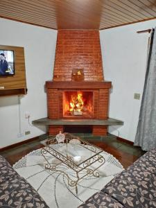 坎波斯杜若尔当Apartamento em Campos do Jordão próximo ao Capivari的客厅的壁炉,前面设有桌子