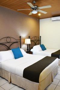 马塔加尔帕Hotel San Jose, Matagalpa.的配有吊扇的酒店客房内的两张床
