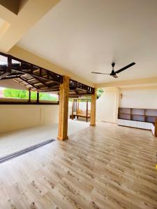 GaafaruStay Salty的空空客房配有吊扇和木地板。