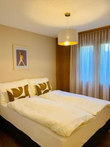 锡格里斯维尔Panorama Boutique Apartment with complimentary Spa access at Solbad Hotel的卧室配有一张大白色床和窗户