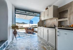 MandrakiaSarakiniko Boat House的一间厨房,配有白色的橱柜,享有海景