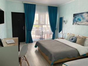 皮聪达Мини-отель ДАРЬЯ в Пицунде的一间卧室配有一张带蓝色窗帘的大床