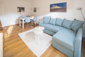 于斯德Appartement Haus Bracht- direkt am Kurplatz的客厅配有蓝色的沙发和桌子