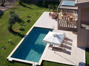 考考纳里斯ELIVI Skiathos的享有带白色遮阳伞的游泳池的顶部景致